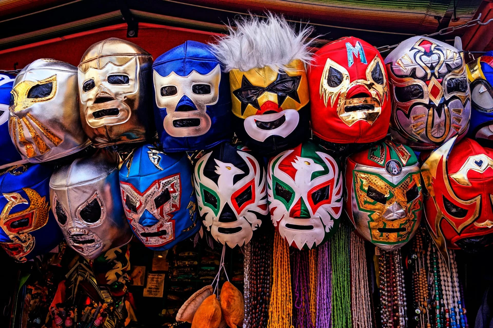 Masked luchadores mid-flight in the ring under bright lights at Arena México in Mexico City