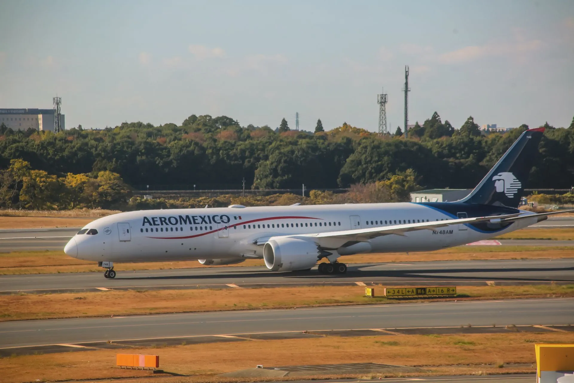 Aircraft at a jet bridge at Mexico City International Airport with the terminal hotel tower behind